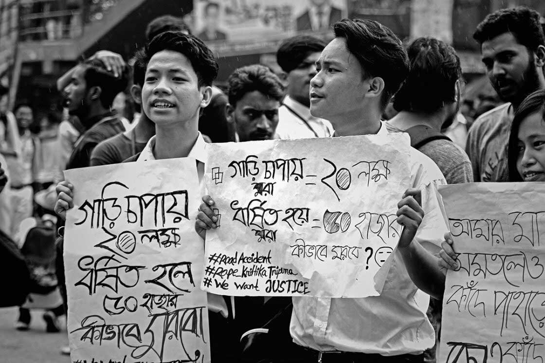   Indigenous students holding placards demanding justice for victims of road accidents and rape.  